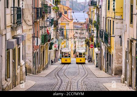 Historische gelbe Standseilbahn in einer steilen Straße in Lissabon, Portugal Stockfoto