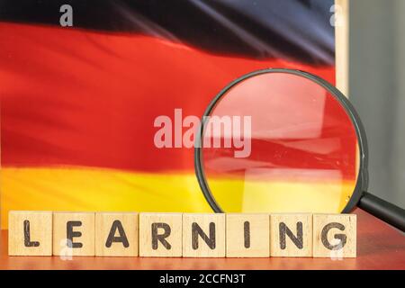 Deutsch Lernkonzept, Flagge und Lernwort auf Holzblock geschrieben Stockfoto