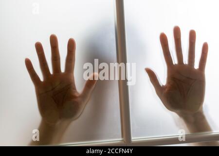 Eine Mädchenhand hinter dem Weichglas Stockfoto