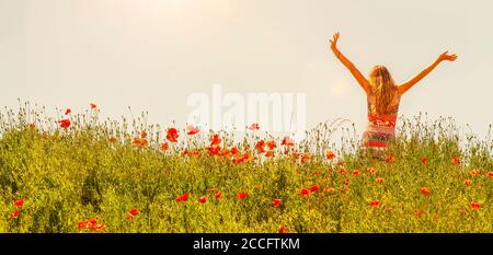 Glückliche Frau trägt Sommerkleid in Mohn Feld Stockfoto