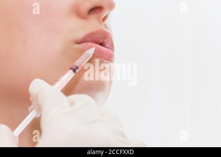 Junge Frau bekommt Injektion in ihre Lippen. Frau im Schönheitssalon. Plastische Chirurgie Klinik. Stockfoto