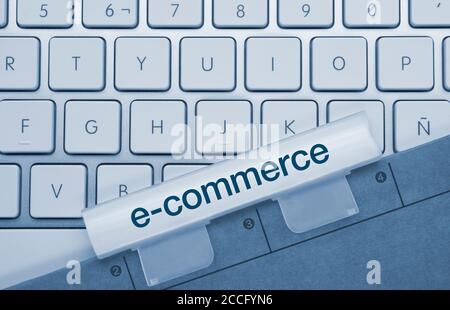 E-Commerce geschrieben auf Blue Key von Metallic Keyboard. Drücken Sie die Taste mit dem Finger. Stockfoto
