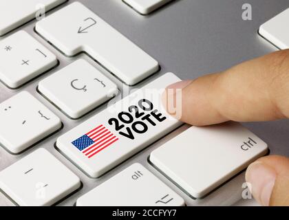 EEUU 2020 STIMME geschrieben auf White Key der metallischen Tastatur. Drücken Sie die Taste mit dem Finger. Stockfoto