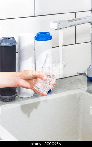 Der Wasserhahn, aus dem das Wasser fließt. Durst löschen. Wasserprobleme in einigen Ländern.das Glas ist mit Wasser gefüllt. Stockfoto