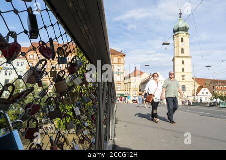 Graz, Österreich. August 2020. Ein Paar, das auf der Erzherzog Johann Brücke geht, wo Liebende ihre Liebesbindung mit den hängenden Schlössern erklären Stockfoto