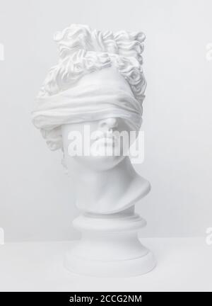 Statue. Rassendiskriminierung. Gipsstatue von Apollos Kopf. Gipsstatue des Apollo in weißem Verband. Unwissenheit. Coronavirus. Geheim. Dunkelheit. Stockfoto