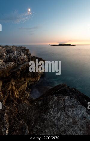 Vollmond und Abendstimmung auf der Halbinsel Kap Kamenjak, Kroatien / Istrien. Eine kleine Insel im Hintergrund Stockfoto