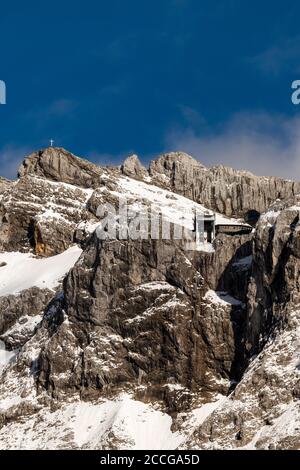 Bergstation der Karwendelbahn im Frühjahr, im Hintergrund die westliche Karwendelspitze und blauer Himmel Stockfoto