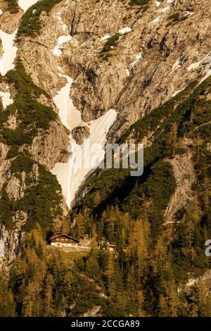 Mittenwalder Hütte im warmen Abendlicht mit Schneefeld Im Hintergrund Stockfoto