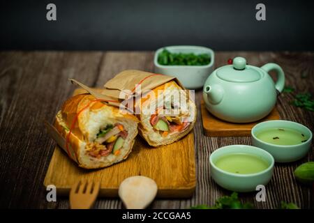 Snack in der Pause. Berühmte vietnamesische Küche ist Banh mi thit und heißer Tee, beliebte Street Food aus Brot gefüllt mit Rohstoff: Schweinefleisch, Schinken, Pastete, zB Stockfoto