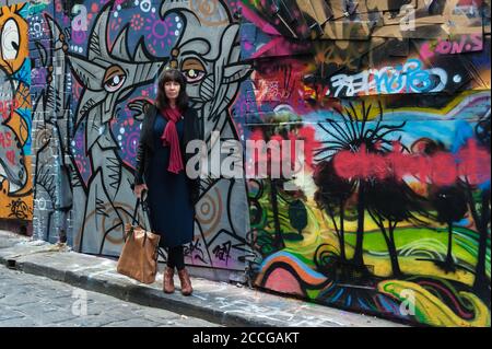 Weibliche Touristen halten an der farbenfrohen Street Art entlang der ACDC Lane in Melbourne, Victoria, Australien. Stockfoto