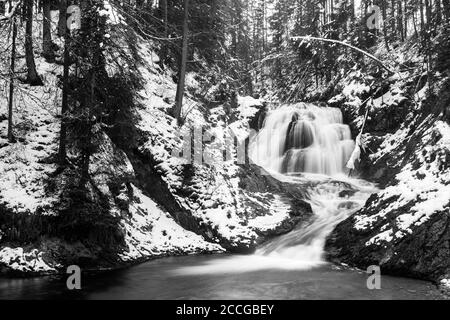 Wasserfall des Obernacher Kanals zwischen Wallgau und Walchensee In den bayerischen Voralpen im Winter mit Schnee Stockfoto