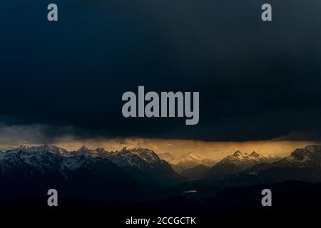 Das Isartal mit dem Karwendel und dem Krün-Stausee im goldenen Abendlicht, während dunkle Sturmwolken darüber liegen. Fotografiert aus dem Herz Stockfoto