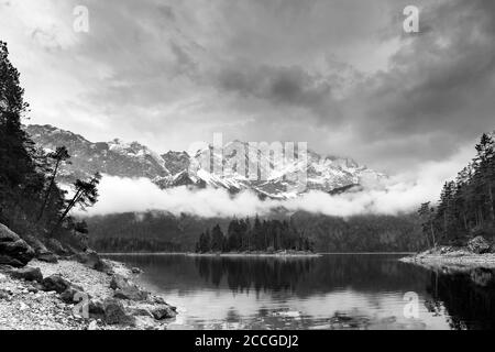 Der Eibsee in der Nähe von Grainau in Bayern, mit der Sasseninsel und im Hintergrund die trübe Zugspitze. Stockfoto