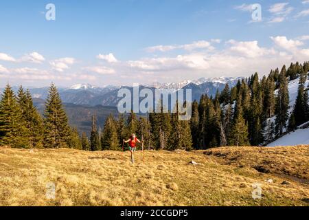 Bergsteiger auf Simetsberg in farbenfroher und sportlicher Kleidung, im Hintergrund die Berge und der Walchensee Stockfoto