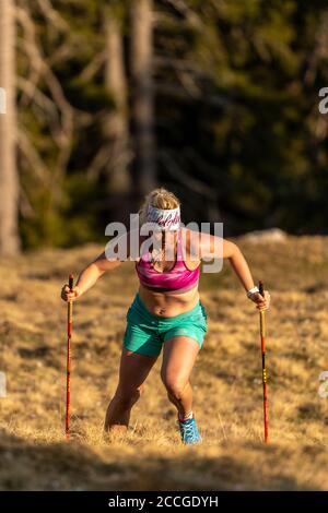 Konzentrierter Trailrunner mit natürlicher Figur beim Berglaufen Auf Simetsberg auf der Frühlingswiese Stockfoto