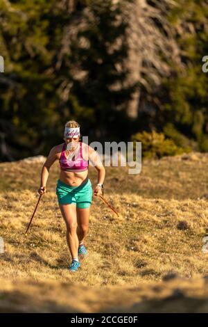 Konzentrierter Trailrunner mit natürlicher Figur beim Berglaufen Auf Simetsberg auf der Frühlingswiese Stockfoto