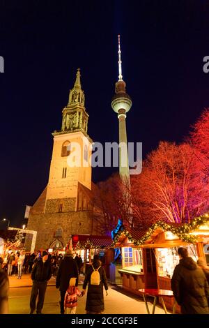 Deutschland, Berlin, Weihnachtsmarkt am Roten Rathaus / Alexanderplatz mit der Marienkirche und dem Fernsehturm. Stockfoto