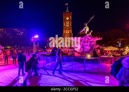 Deutschland, Berlin, Weihnachtsmarkt am Roten Rathaus / Alexanderplatz mit Eislaufbahn rund um den Neptunbrunnen. Stockfoto