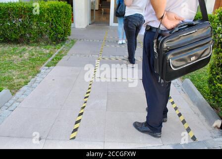 Soziale Distanzierung. Die Menschen, die an einem Geldautomaten mit einem Schild auf dem Boden warten, zeigen die notwendige soziale Distanz aufgrund einer Coronavirus-Pandemie an. Ankara Stockfoto