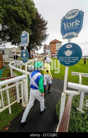 Eine allgemeine Ansicht, wie Jockeys den Paradering während des vierten Tages des Yorkshire Ebor Festivals auf der York Racecourse betreten. Stockfoto