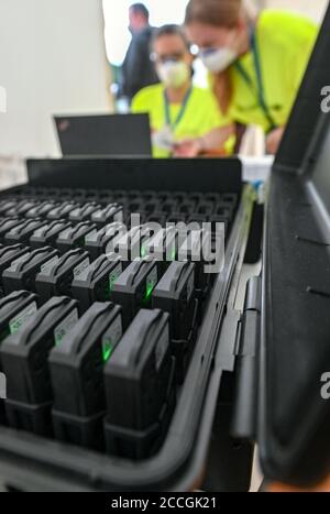 22. August 2020, Sachsen, Leipzig: Sogenannte Tracer zur Rückverfolgung der Bewegungen der Probanden befinden sich an einem Check-in während eines Großversuchs der Universitätsmedizin Halle/Saale in der Arena Leipzig. Rund 2200 Besucher nehmen an dem Experiment 'Restart-19' Teil, bei dem der Popsänger Tim Bendzko auftritt. Die Wissenschaftler wollen mit Sensoren und anderen Hilfsmitteln ihre Gehwege überwachen und fluoreszierendes Desinfektionsmittel soll sichtbar machen, welche Oberflächen besonders häufig berührt werden. Der Flug von Aerosolen - die kleinsten Mischungen von Partikeln, die das Virus tragen können - wi Stockfoto