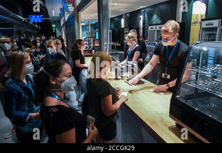 22. August 2020, Sachsen, Leipzig: Testpersonen eines Großversuchs der Universitätsmedizin Halle/Saale stehen an einem Kiosk in der Arena Leipzig in der Schlange. Rund 2200 Besucher nehmen an dem Experiment 'Restart-19' Teil, bei dem Popsänger Tim Bendzko auftreten wird. Die Wissenschaftler wollen mit Sensoren und anderen Hilfsmitteln ihre Gehwege überwachen, fluoreszierendes Desinfektionsmittel soll sichtbar machen, welche Oberflächen besonders häufig berührt werden. Auch der Flug von Aerosolen - den kleinsten Gemischen von Partikeln, die das Virus tragen können - wird verfolgt. Ziel ist es, ein mathematisches Modell zu entwickeln, das Stockfoto