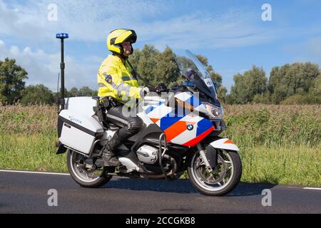 Motorrad Polizist Reiten in ländlicher Landschaft in der Nähe von Urk, Niederlande Stockfoto