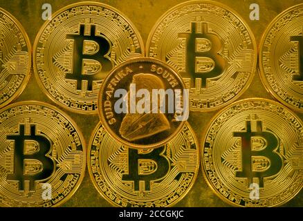 Physische Goldmünze 1 Unze Gold Krugerrand Vorderseite Paul Kruger auf Bitcoin-Münzen, symbolisches Bild Gold versus Kryptowährung Stockfoto