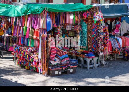 Mexikanischer Marktstand, der lokale Handarbeitsmaterialien Decken und Kleidung verkauft In Oaxaca Stockfoto