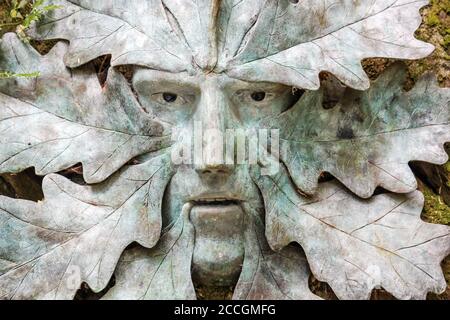 Tim Shaws Skulptur. Der Grüne Mann. In der Nähe des Bath House Quarry Pool bei Anthony Woodlands, Torpoint Cornwall gefunden. Landschaftlich gestaltete Gärten am Ufer von Stockfoto