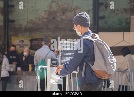 Sydney, Australien. August 2020. Ein Mann benutzt am 22. August 2020 Handdesinfektionsmittel auf dem Carriageworks Farmers Market in Sydney, Australien. Carriageworks wurde zwischen 1880 und 1889 als Teil der Eveleigh Railway Workshops gebaut. Im Jahr 2007 wurde das Gelände als Kulturviertel neu entwickelt. Heute ist Carriageworks ein bedeutendes Multi-Arts-Zentrum in Australien. Quelle: Hu Jingchen/Xinhua/Alamy Live News Stockfoto