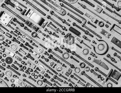 Satz von alten rostigen Metallschrauben, Muttern und Schrauben schwarz-weiß Foto. Flach liegend, Draufsicht Stockfoto