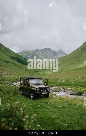 Oldtimer 4x4 SUV Auto geparkt zwischen den grünen Bergen von Der Fluss Stockfoto