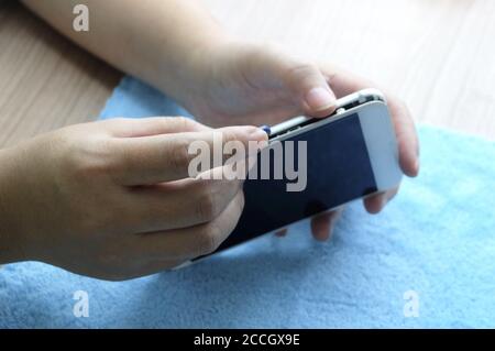 Nahaufnahme des Technikers Smartphone mit Schraubendreher auf dem Tisch öffnen und reparieren. Stockfoto