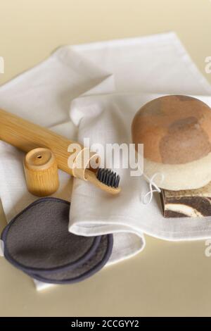 Natürliche Öko Zahnbürste, handgemachte Seife, wiederverwendbare Bambus Make-up-Entferner Pads und Schwamm auf weißem Handtuch. Stockfoto