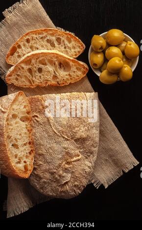 Ciabatta. Frisches italienisches Ciabatta-Brot mit Kräutern, Olivenöl und Oliven, Kopierraum. Stockfoto