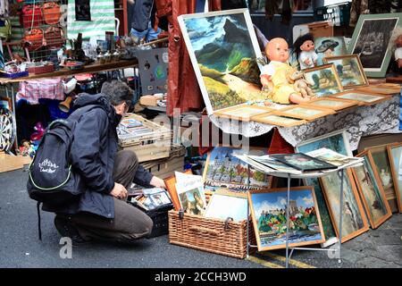 London, UK, July 1, 2012 : Kunden, die Antiquitäten an einem Stand in Brick Lane Street Market Whitechapel, die ein beliebtes Reiseziel tou ist Stockfoto