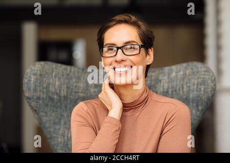 Nahaufnahme Porträt einer schönen Geschäftsfrau auf einem sitzen Sessel in der Wohnung Stockfoto