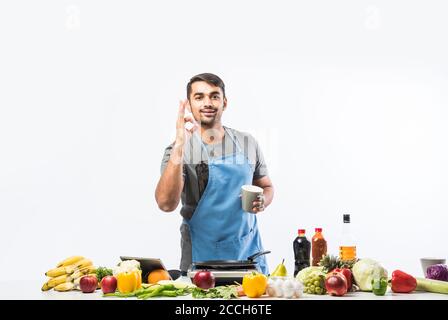 Gutaussehende fröhlich lächelnden indischen Mann Zubereitung von Essen in der Küche, gesundes Essen, Kochkonzept. Stockfoto