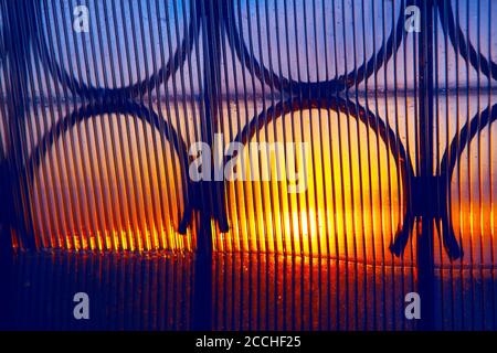 Sonnenuntergang in Wellglas . Dämmerung im Fenster mit Rost Stockfoto