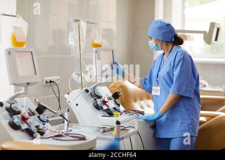 Laborwissenschaftler, der Reagenzgläser mit Blutproben in Zentrifuge platziert Stockfoto