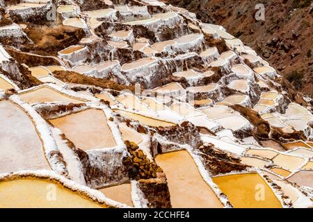 Salzteiche in Maras, Peru. Seit der Zeit vor der Inka wurde in Maras Salz gewonnen, indem Salzwasser aus einem lokalen unterirdischen Bach verdunstet wurde. Stockfoto