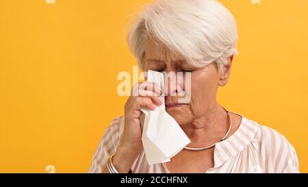 Porträt einer einsamen traurigen verletzlichen alten Frau, die ihre Tränen auswischt. Hochwertige Fotos Stockfoto