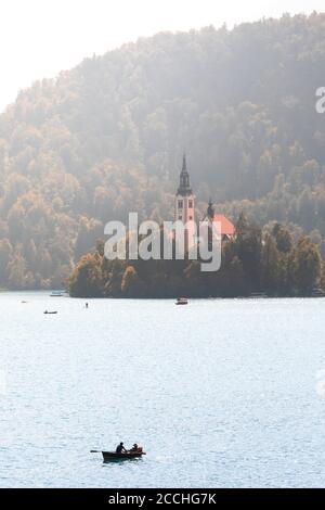 Nahaufnahme der ikonischen Insel mitten im Bleder See im Sommer, mit Ruderbooten, die auf dem Wasser gleiten Stockfoto