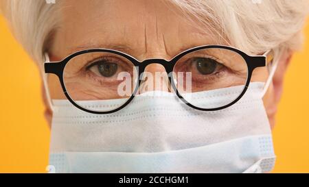 Nahaufnahme der traurigen alten Frau mit Brille und medizinischer Maske. Schützen Sie gefährdete Menschen. Hochwertige Fotos Stockfoto