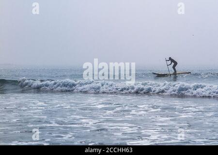 Ein einesenPaddle Boarder im Meer auf der Devonshire Küste im Atlantischen Ozean Stockfoto