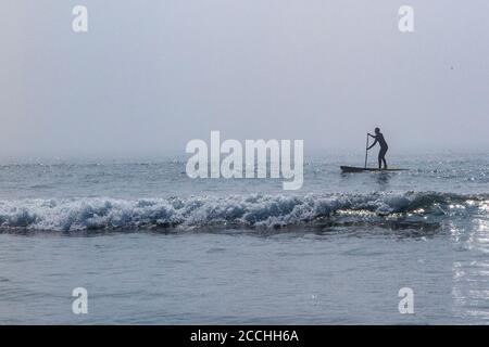 Ein einesenPaddle Boarder im Meer auf der Devonshire Küste im Atlantischen Ozean Stockfoto