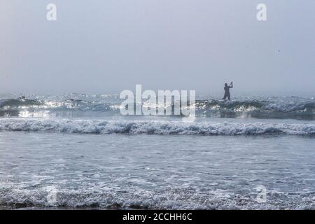 Ein einesenPaddle Boarder im Meer auf der Devonshire Küste im Atlantischen Ozean Stockfoto