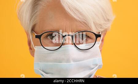 Nahaufnahme, Porträt einer ernsthaften älteren Frau mit Brille und medizinischer Maske. Hochwertige Fotos Stockfoto